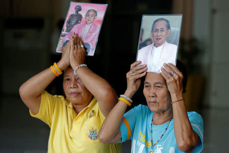 Well-wishers hold portraits of Thailand's King Bhumibol Adulyadej at Siriraj Hospital in Bangkok, Thailand, October 10, 2016. REUTERS/Chaiwat Subprasom