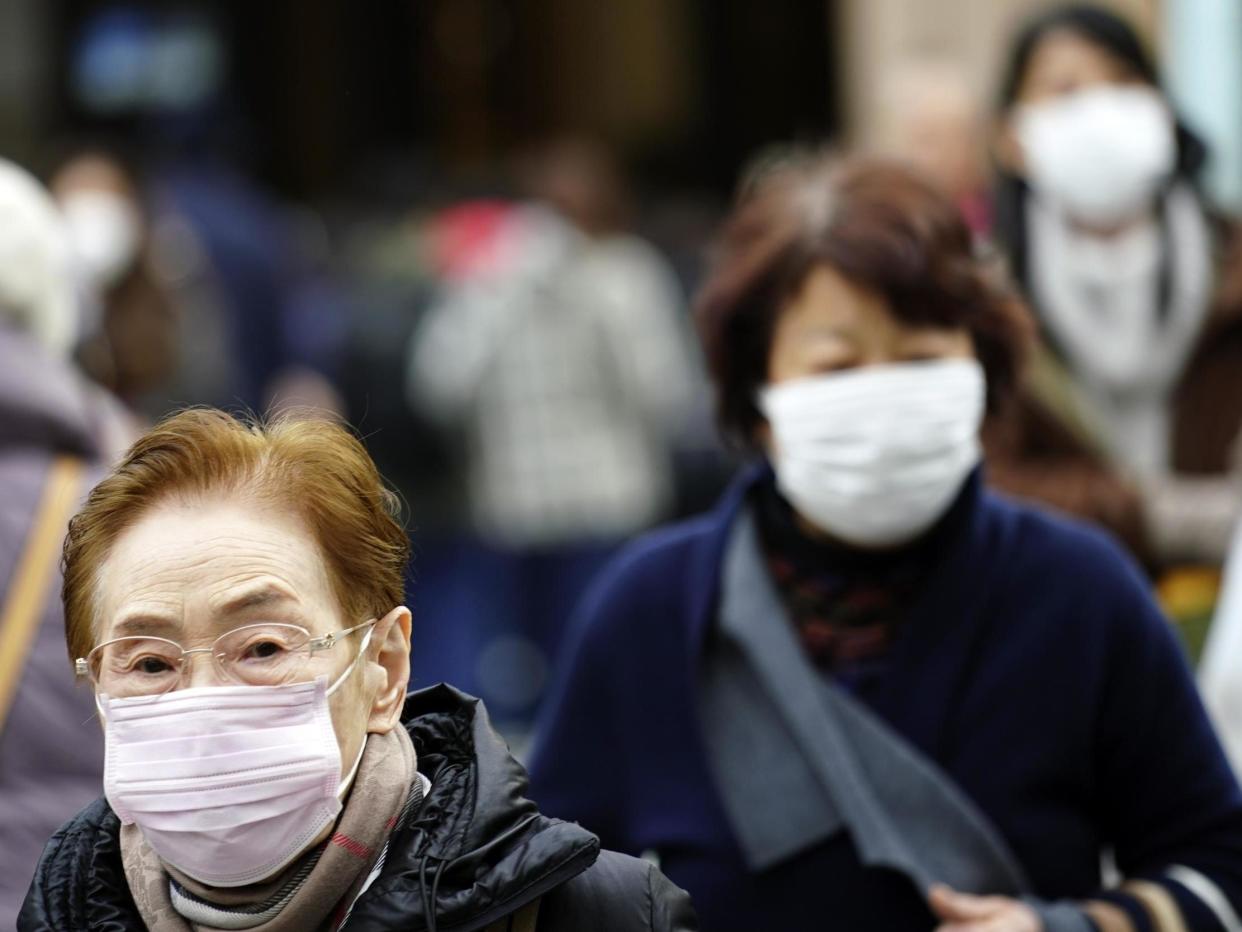 Pedestrians wear protective masks as they walk through a shopping district in Tokyo Thursday Jan 16 2020: AP