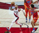 Portland Trail Blazers guard Damian Lillard, left, drives to the basket past Oklahoma City Thunder forward Isaiah Roby during the first half of an NBA basketball game in Portland, Ore., Monday, Jan. 25, 2021. (AP Photo/Craig Mitchelldyer)