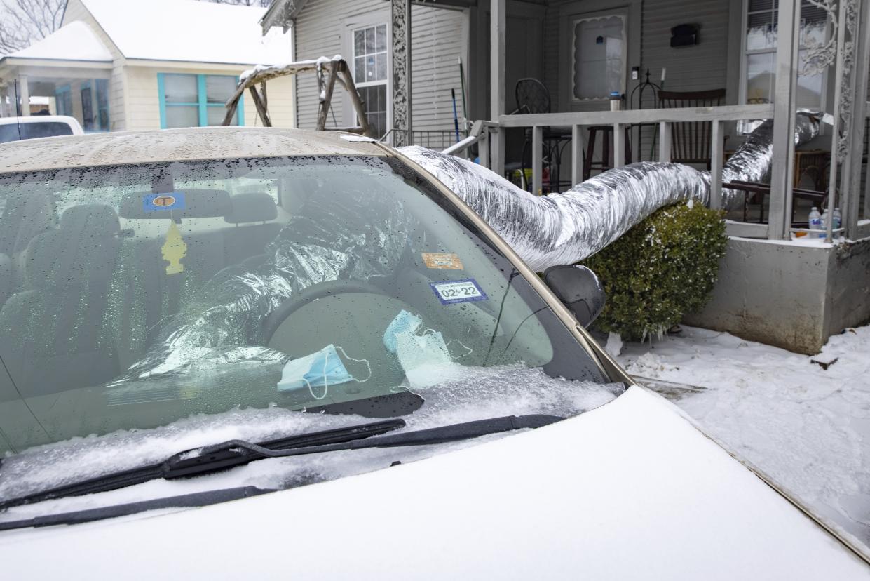 Leonel Solis and Estefani Garcia use their car to heat their home in East Dallas area of Dallas on Wednesday, Feb. 17. The couple, who lost power on Sunday, have been using electricity from a neighbor's generator and heat from their car to stay warm after seeing it on TikTok. 