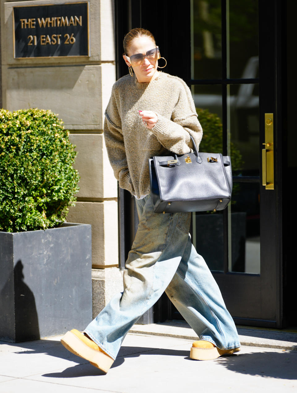 jennifer lopez walks around New York City in jeans, platform Uggs, and a sweater