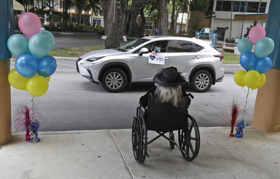 FILE- In this July 17, 2020, file photo, Frances Reaves, in car, pays a visit to her friend Margaret Choinacki, foreground, 87, who has no other family members left because her husband and daughter have died, at Miami Jewish Health in Miami. Floridians will soon be allowed to visit loved ones in nursing homes after nearly six months of vulnerable seniors being cut off from family as Gov. Ron DeSantis announced Tuesday, Sept. 1, 2020, that facilities could start a partial reopening. (AP Photo/Wilfredo Lee, File)