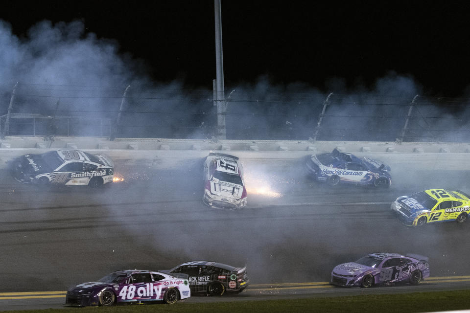 Aric Almirola (10), Brad Keselowski (6), Kyle Larson (5), Ryan Blaney (12), Daniel Suarez (99), and Travis Pastrana (67), and Alex Bowman (48) crash during the NASCAR Daytona 500 auto race Sunday, Feb. 19, 2023, at Daytona International Speedway in Daytona Beach, Fla. (AP Photo/Laura Domingue)