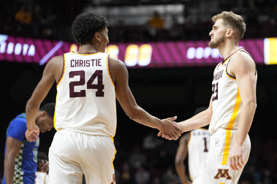 Minnesota guard Cam Christie (24) and forward Parker Fox shake hands during the second half of an NCAA college basketball game against Florida Gulf Coast, Saturday, Dec. 9, 2023, in Minneapolis. (AP Photo/Abbie Parr)