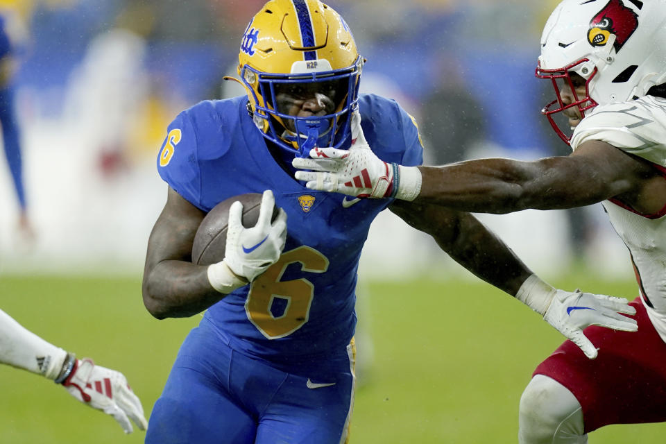 Pittsburgh running back Rodney Hammond Jr. (6) carries the ball as he's pressured by Louisville linebacker TJ Quinn during the first half of an NCAA college football game in Pittsburgh, Saturday, Oct. 14, 2023. (AP Photo/Matt Freed)