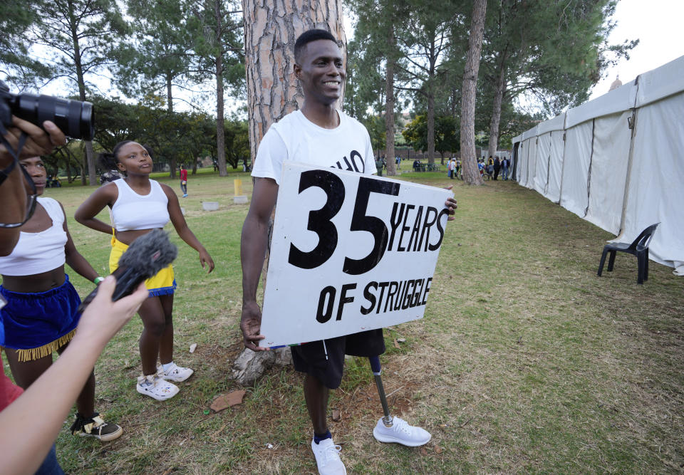 A protester holds a poster as he attends Freedom Day celebrations in Pretoria, South Africa, Saturday April 27, 2024. The day marks April 27 when the country held pivotal first democratic election in 1994 that announced the official end of the racial segregation and oppression of apartheid. (AP Photo/Themba Hadebe)