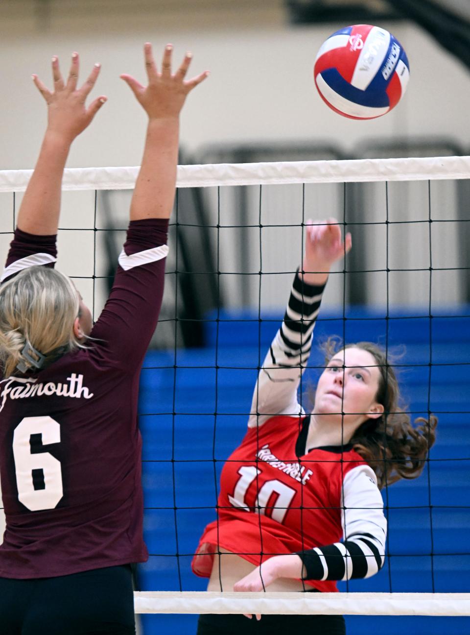Molly Gleason of Barnstable spikes the ball past Maci Griesbauer of Falmouth.