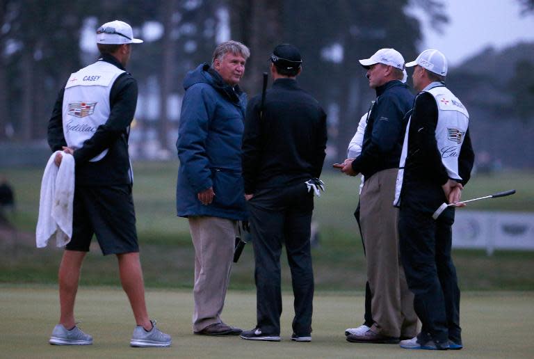 The match referee (2nd R) talks to Rory McIlroy and Paul Casey on halting play for the day because of fading light during the quarter final match in the World Golf Championships Cadillac Match Play at TPC Harding Park on May 2, 2015