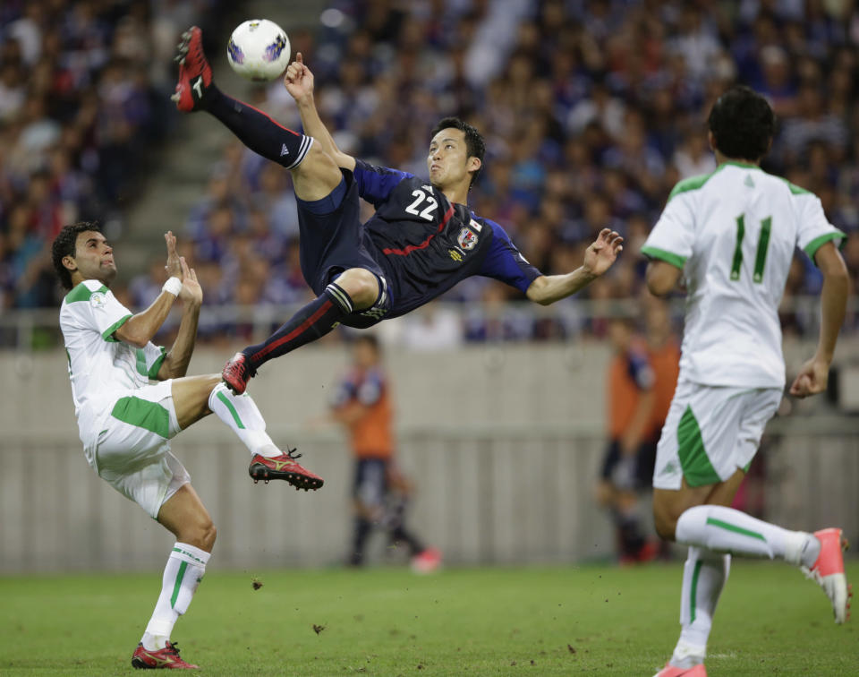 Japan's Maya Yoshida (C) shoots the ball between Iraq's Waleed Salim (L) and Amjed Radhi Yousuf Al-Janabi during their 2014 World Cup qualification soccer match in Saitama, north of Tokyo, September 11, 2012. REUTERS/Toru Hanai (JAPAN - Tags: SPORT SOCCER)