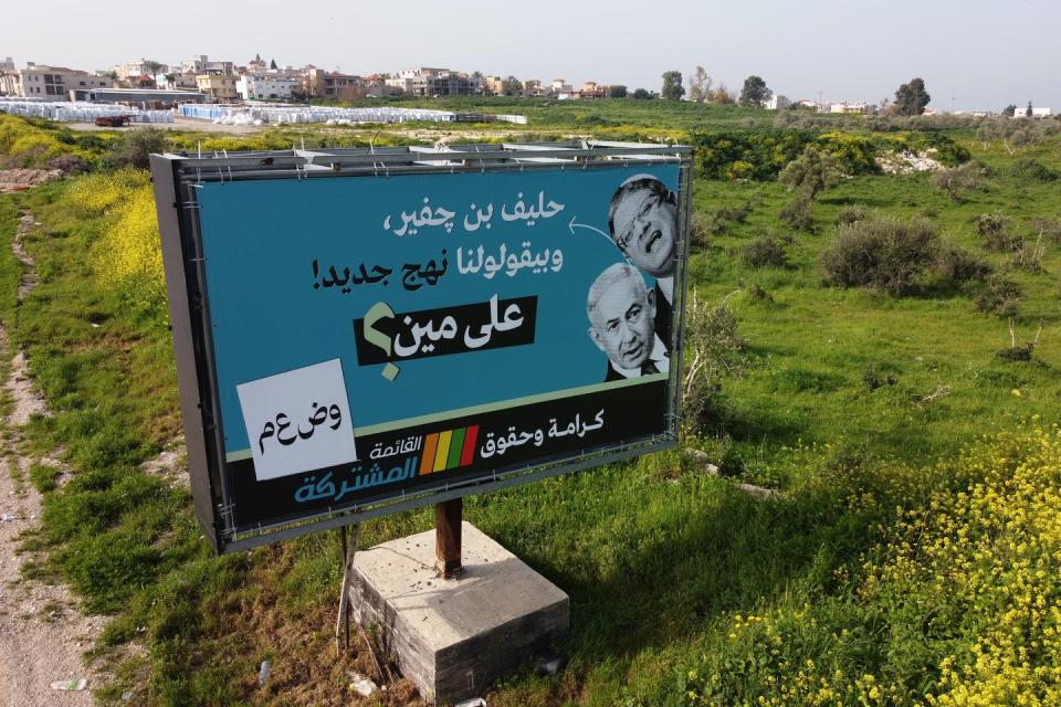 A campaign billboard for Arab parties in Arabic with pictures of Israeli Prime Minister Benjamin Netanyahu and Israeli far-right leader Itamar Ben Gvir.