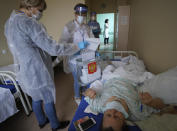 Medical workers cast a patient's ballot at a hospital during the Parliamentary elections in Voronezh, Russia, Sunday, Sept. 19, 2021. Russia has begun the third day of voting for a new parliament that is unlikely to change the country's political complexion. There's no expectation that United Russia, the party devoted to President Vladimir Putin, will lose its dominance in the State Duma. (AP Photo/Alexei Sazonov)