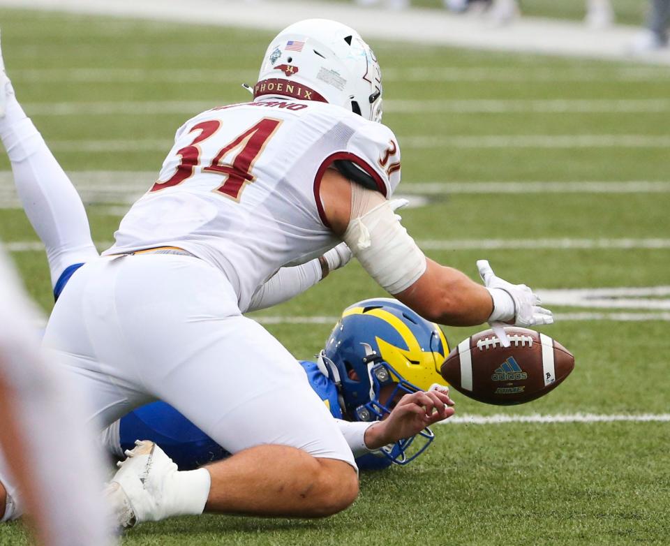 Delaware quarterback Ryan O'Connor loses a fight to recover his fumble to Elon's Marco Patierno (34) ending Delaware's hopes of completing the comeback OConnor was engineering late in the fourth quarter of the Blue Hens' 33-27 loss at Delaware Stadium, Saturday, Nov. 4, 2023.