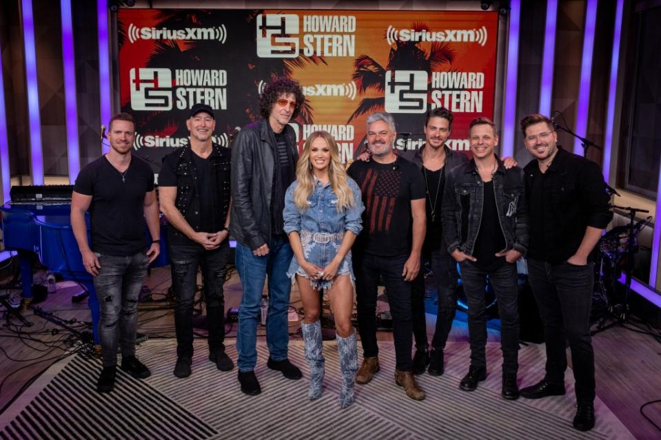 MIAMI BEACH, FLORIDA - MAY 03: (L-R) Matt Reviere, Scott Sheriff, Howard Stern, Carrie Underwood, Mark Childers, Seth Rausch, Ed Eason and Jordan Lawson pose at The Howard Stern Show at the SiriusXM Miami studios on May 03, 2023 in Miami Beach, Florida. (Photo by Emma McIntyre/Getty Images for SiriusXM)