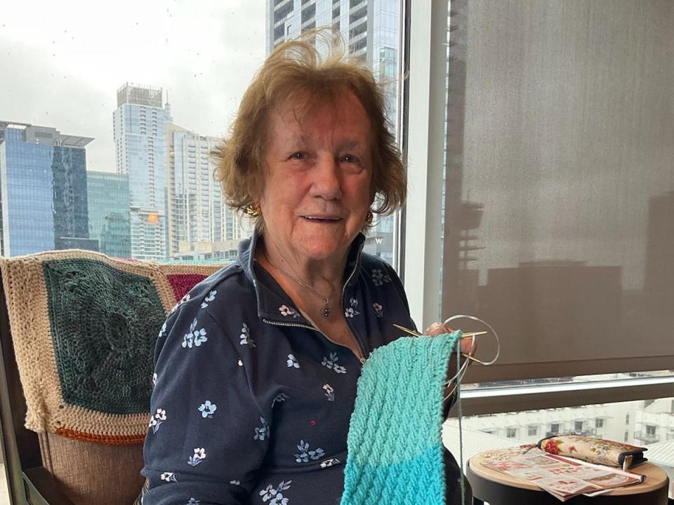 Meredith Wilshere's grandmother sitting at a table and knitting.
