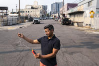 FILE - Vivek Shandas, a professor of climate adaptation at Portland State University, takes a temperature reading of almost 106 degrees in downtown Thursday, Aug. 12, 2021, in Portland, Ore., during a major, multi-day heat wave. According to three different reports released Monday, Jan. 10, 2021, the United States staggered through a steady onslaught of deadly billion-dollar climate disasters in an extra hot 2021, while the nation’s greenhouse gas emissions last year jumped 6% because of surges in coal and long-haul trucking, putting America further behind its 2030 climate change cutting goal. (AP Photo/Nathan Howard, File)