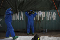 French emergency workers, part of a special unit working with chemicals, suit up near the site of last week's explosion, in the port of Beirut, Lebanon, Monday, Aug. 10, 2020. The unit is identifying potential leaks and securing an area where containers with flammable liquids have been damaged by the blast. (AP Photo/Felipe Dana)