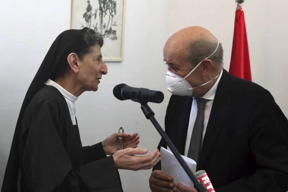 Lebanese head principal of the Carmel Saint Joseph school Mother Antoinette Oweit, left, speaks with French Foreign Minister Jean-Yves Le Drian, during his visit to the school in Mechref district, south of the capital Beirut, Lebanon, Friday, July 24, 2020. Le Drian pledged on Friday €15 million ($17 million) in aid to Lebanon's schools, struggling under the weight of the country's major economic crisis. (AP Photo/Bilal Hussein)