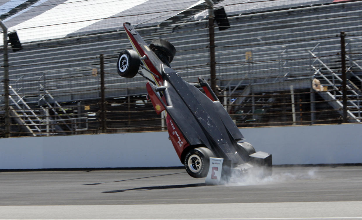 El momento en que el auto de Helio Castroneves vuelta por el aire en Indianápolis. (AP Photo/Joe Watts)