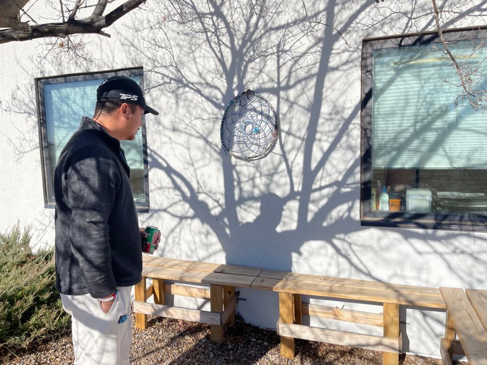 Gary Whipple, Honor's uncle, shows a visitor the bench that Honor built with his classmates at Sapa Un Jesuit Academy in St. Francis, S.D. It has now become a memorial to the boy's impact on the school.