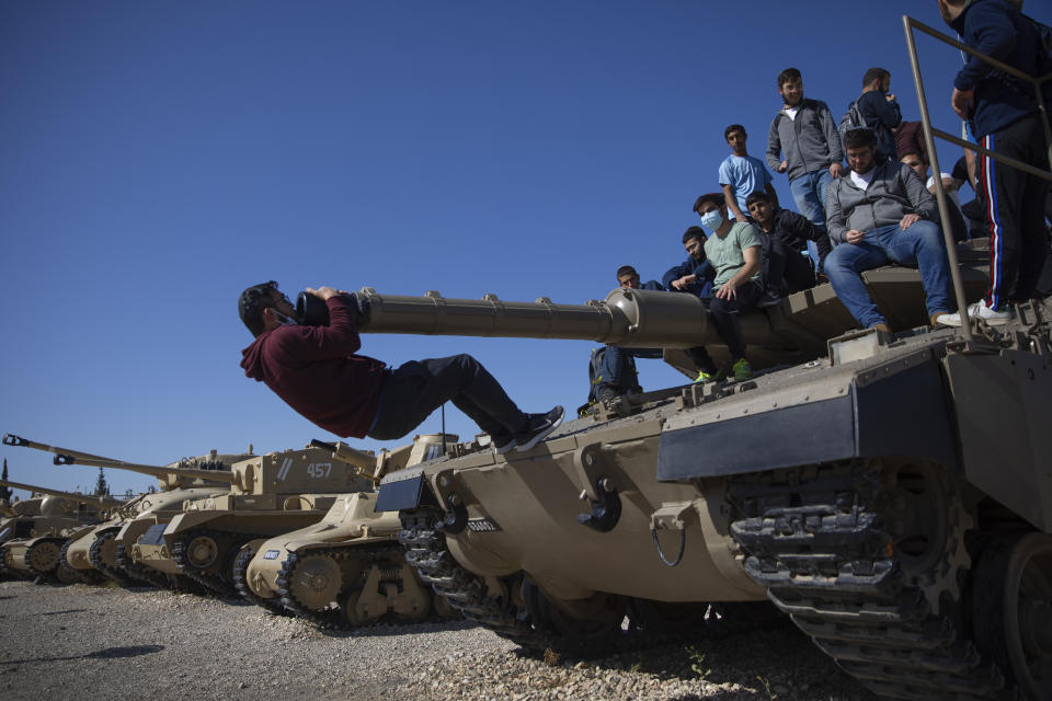 Students climb on a tank during a ceremony marking the annual Memorial Day to remember fallen soldiers and victims of terror, at the Armored Corps memorial site in Latrun, Israel, Wednesday, April 14, 2021. (AP Photo/Oded Balilty)