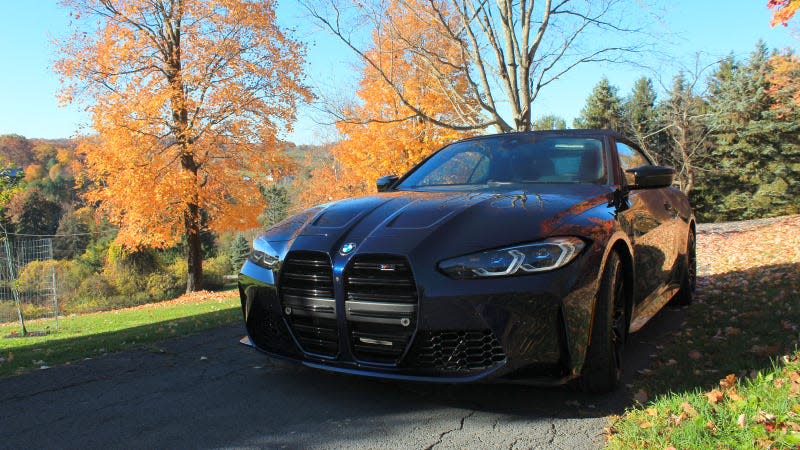 A photo of the front quarter on a convertible BMW M4 sports car in blue. 