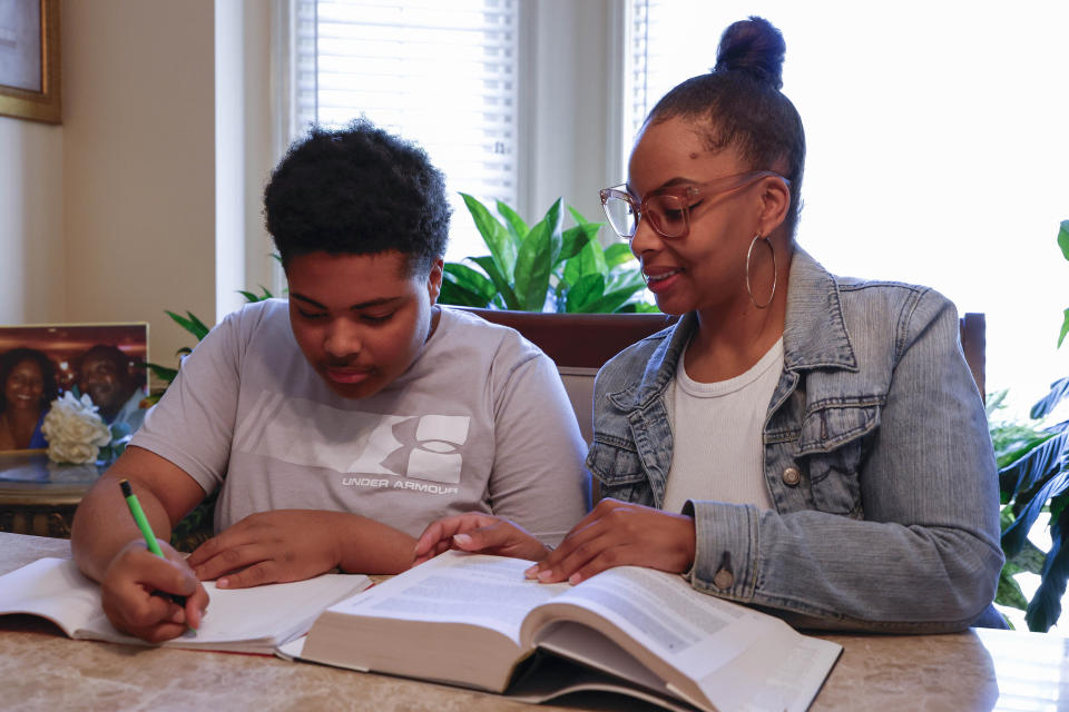 Adriane Burnett helps her son Josiah with his studies on Saturday, April 14, 2024 in Birmingham, Ala. Women's participation in the American workforce has reached a high point, but challenges around child care are holding back many working class parents. When women without college degrees face an interruption in child care arrangements – whether it's at a relative's home, a preschool or a daycare center – they are more likely to have to take unpaid time or to be forced to leave their jobs altogether, according to an Associated Press analysis. (AP Photo/Butch Dill)