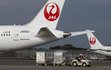 A airport worker drives a luggage transport vehicle past one of the company's Boeing Co's 787 Dreamliner plane (L) and a Beoing 767 at Narita international airport in Narita, east of Tokyo, November 11, 2013. REUTERS/Toru Hanai