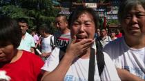 A still frame grab from AFPTV video shows relatives of those onboard missing Malaysia Airlines flight MH370 grieving as they visit Yonghe Temple in Beijing on September 8, 2014