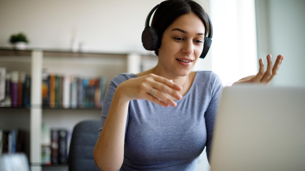 Young woman having video call on laptop computer at home.