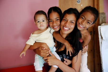 Geraldine Rocca, 29, (2nd R) poses for a picture with her children (L-R) Jeremy, Nicole and Janna, ahead of her sterilization surgery in Caracas, Venezuela July 20, 2016. REUTERS/Carlos Garcia Rawlins