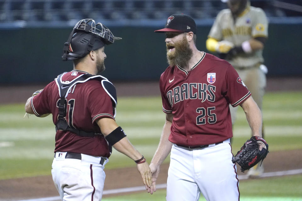 Arizona Diamondbacks pitcher Archie Bradley, right, and Stephen Vogt, left, celebrate after defeating the San Diego Padres in a baseball game, Sunday, Aug 16, 2020, in Phoenix. (AP Photo/Rick Scuteri)