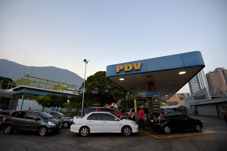 Cars wait in line at a gas station in Caracas on February 17, 2016 after President Nicolas Maduro said he would raise the price of gasoline for the first time in 20 years