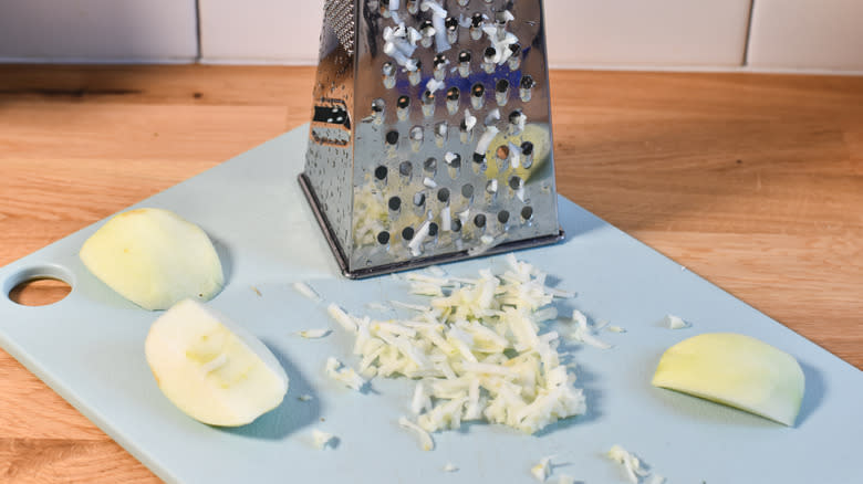 grating apples on cutting board