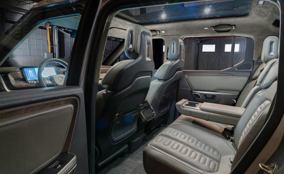 <p>Real wood is used throughout, and Rivian's designers have taken care to choose colors and materials inspired by the natural world, with the design scheme shown here featuring dark green leather and brown wood.</p>