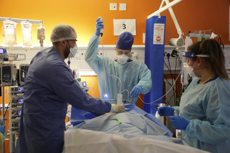 Critical Care staff carry out a tracheostomy procedure on a COVID-19 patient on the Christine Brown ward at King's College Hospital in London, Wednesday, Jan. 27, 2021. (AP Photo/Kirsty Wigglesworth, Pool)