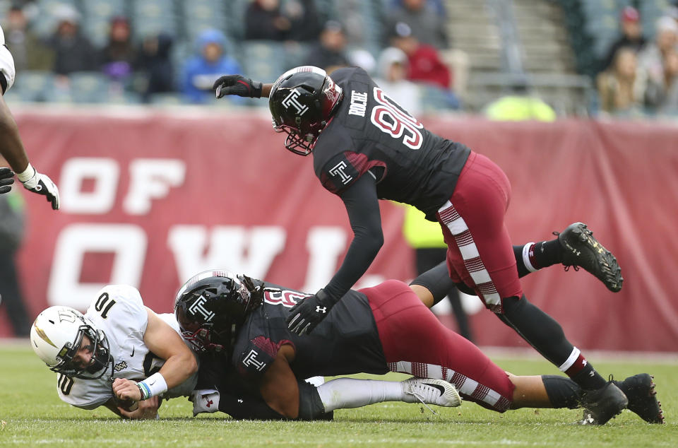 Central Florida quarterback McKenzie Milton (10) is sacked by Temple’s Sharif Finch (6) and Quincy Roche (90) during the second quarter of an NCAA college football game Saturday, Nov. 18, 2017, in Philadelphia. (AP Photo/Rich Schultz)