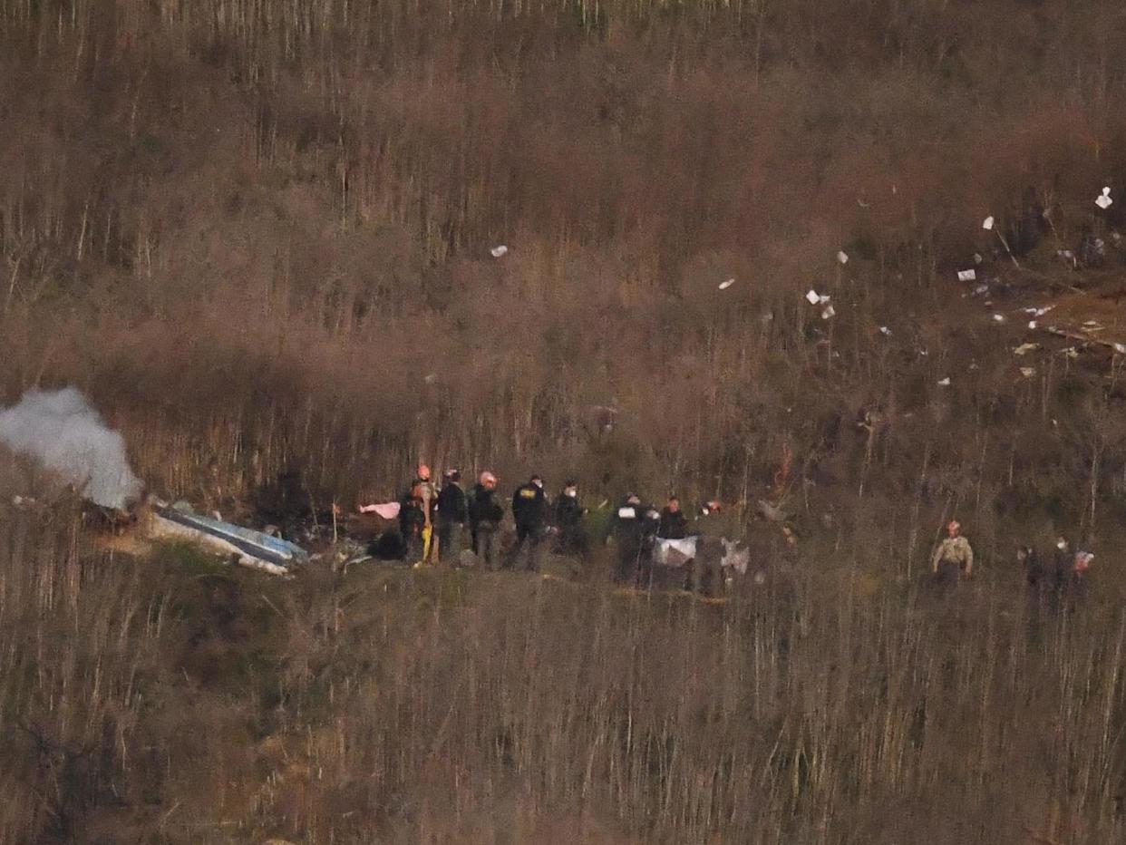 A body is carried from the scene of a helicopter crash that killed former NBA basketball player Kobe Bryant, his daughter and several others: AP