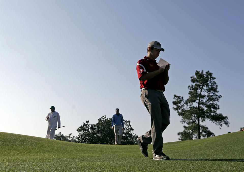 Louis Oosthuizen, of South Africa, followed by Matt Kuchar walk off the first tee during the second round of the Masters golf tournament Friday, April 11, 2014, in Augusta, Ga. (AP Photo/Darron Cummings)