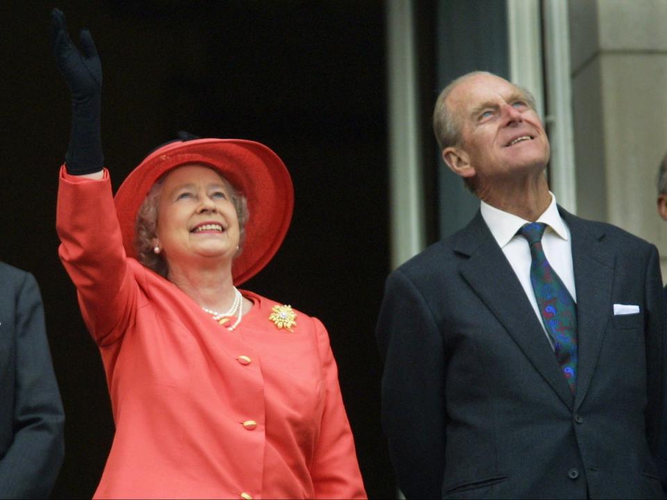 Queen Elizabeth II and Prince Philip look up from the balcony of Buckingham Palace as Concorde flies past during the Golden Jubilee celebrations in London (AFP via Getty Images)