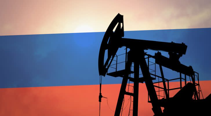 An oil pump with the Russian flag in the background. Energy stocks