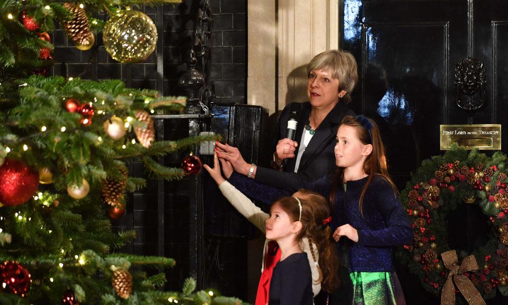 Theresa May is joined by some children to switch on the Downing Street Christmas tree lights