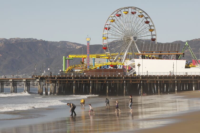 SANTA MONICA, CA - JANUARY 11: Pedestrians Monday morning enjoy the beautiful weather along the Santa Monica beach which remains open at all times. But out of an abundance of caution and to contribute to regional efforts to slow the spread of COVID-19 in Los Angeles County, the Santa Monica Pier will be temporarily closed the remaining weekends in January. The Pier remains open to pedestrians Monday Through Friday 6 a.m. to 10 p.m. The best way to slow the spread of COVID-19 is to stay home as much as possible and the closure is part of meeting this need. Santa Monica Pier on Monday, Jan. 11, 2021 in Santa Monica, CA. (Al Seib / Los Angeles Times)