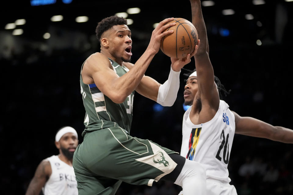 Milwaukee Bucks forward Giannis Antetokounmpo (34) looks to pass on a drive against Brooklyn Nets center Day'Ron Sharpe (20) during the second half of an NBA basketball game, Tuesday, Feb. 28, 2023, in New York. (AP Photo/John Minchillo)