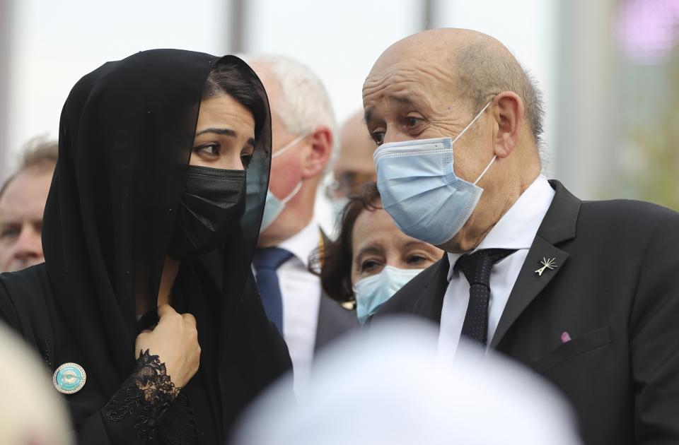 French Foreign Affairs Minister Jean-Yves Le Drian, right, and Reem Ebrahim Al-Hashimi, Minister of State and Managing Director for the Dubai World Expo 2020, talk to each other at the French Pavilion of the Dubai Expo 2020 in Dubai, United Arab Emirates, Saturday, Oct. 2, 2021. (AP Photo/Kamran Jebreili)