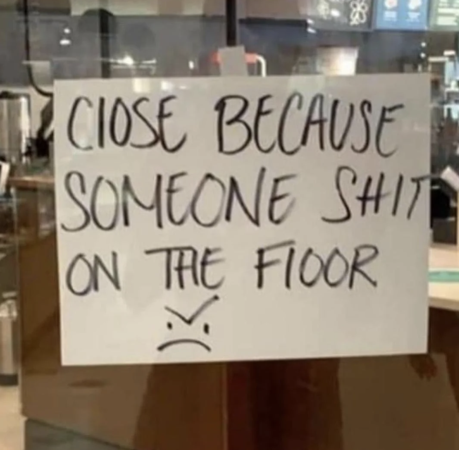 Handwritten sign saying a place is closed due to someone defecating on the floor, with a sad face drawn below