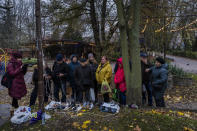 Residents plug in mobile phones and power banks at a charging point in downtown Kherson, southern Ukraine, Sunday, Nov. 20, 2022. Russian forces fired tank shells, rockets and other artillery on the city of Kherson, which was recently liberated from Ukrainian forces. (AP Photo/Bernat Armangue)