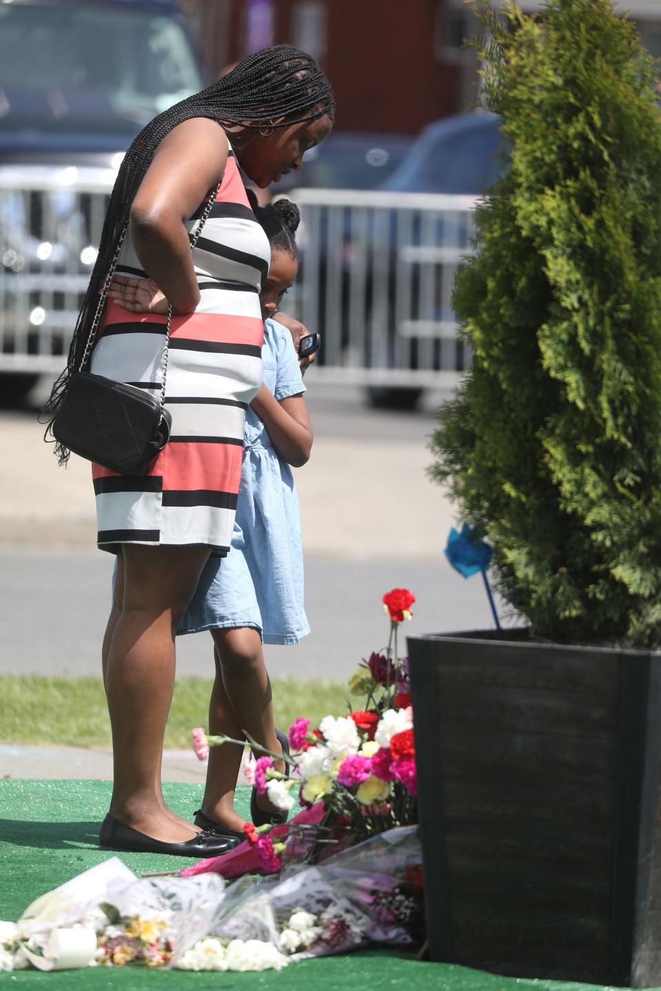 On the first anniversary of the Tops shooting in Buffalo, Shamara Cross of Buffalo and her daughter, Shayla, 6, came after church to pay respects to the 10 residents who were killed.