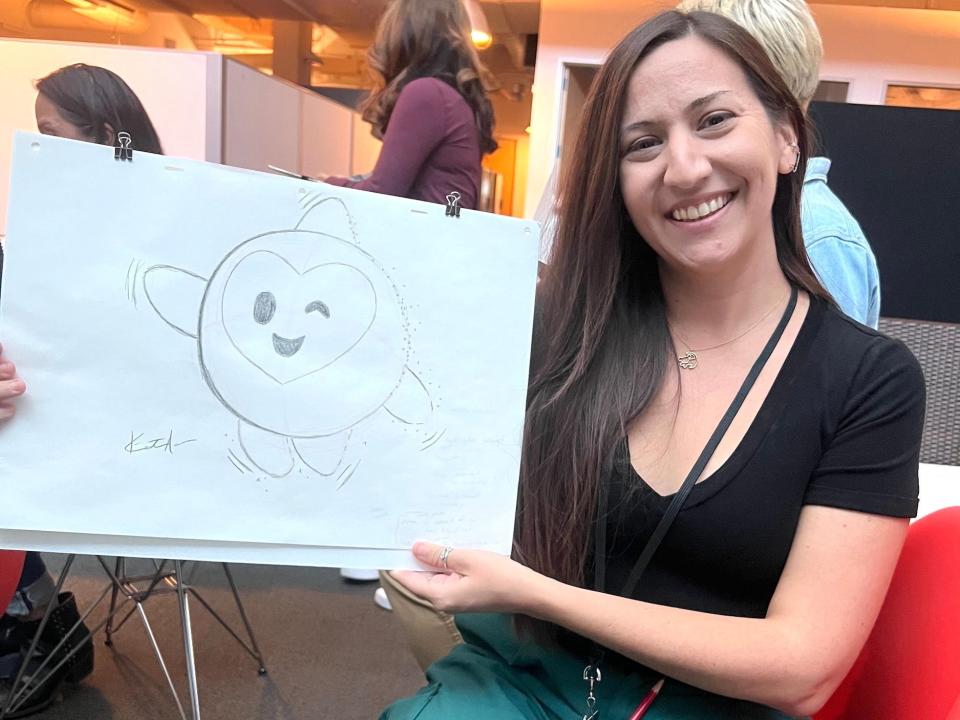 Kirsten Acuna sits holding a drawing of Star from "Wish" she drew.