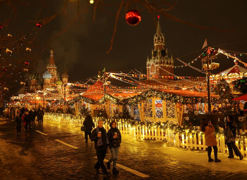 FILE PHOTO: People walk past a Christmas market in Red Square in Moscow