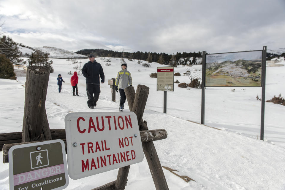 A family visits the Terraces Mammoth Hot Springs at Yellowstone National Park on Jan. 3, 2019 in Yellowstone, Wyoming. Non-Emergency services in Yellowstone National Park have been suspended during the current government shutdown. Visitors are still allowed access to the parks attractions but services are limited. (Photo: William Campbell/Corbis via Getty Images)